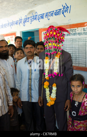 Sposo indossando il tradizionale copricapo indiano al matrimonio nel villaggio di Rohet nel Rajasthan, India settentrionale Foto Stock