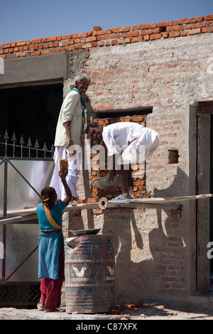 Gli uomini e le donne che lavorano sul sito in costruzione nel villaggio Jawali nel Rajasthan, India settentrionale Foto Stock