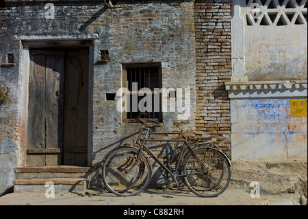 Biciclette puntellato sul vecchio edificio nel villaggio Narlai nel Rajasthan, India settentrionale Foto Stock