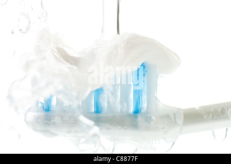 Wet spazzolino da denti con dentifricio isolato su bianco Foto Stock