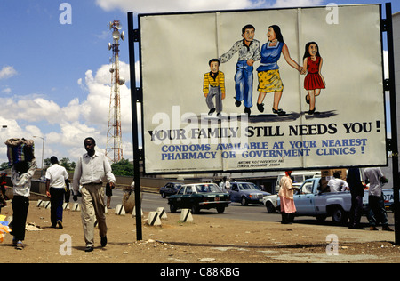 Lusaka, Zambia, Africa. Poster Anti-Aids accanto ad una strada trafficata con relè di telecomunicazioni torre dietro. Foto Stock