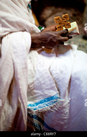 Un cristiano ortodosso sacerdote legge preghiere accanto alla tomba di Re Lalibela in rock-scavato nella chiesa di scommettere sul Golgota in Lalibela. Foto Stock