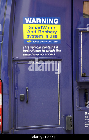 Smart acqua anti rapina segno di sistema sul retro di un blindato di erogazione di cassa carrello in Belfast City Centre Irlanda del Nord Regno Unito Foto Stock