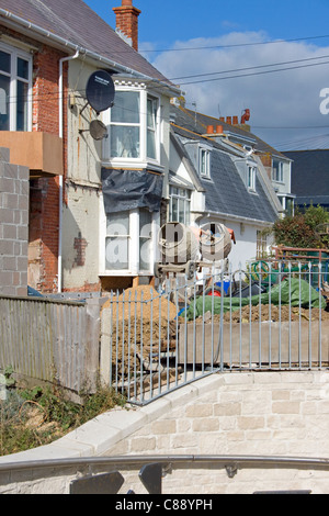 Miscelatori di cemento e materiali da costruzione in un giardino durante una casa di ristrutturazione. Foto Stock