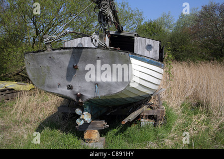 Abbandonato clinker in legno yacht costruito nel cantiere di campo, Orford, Suffolk, Regno Unito Foto Stock