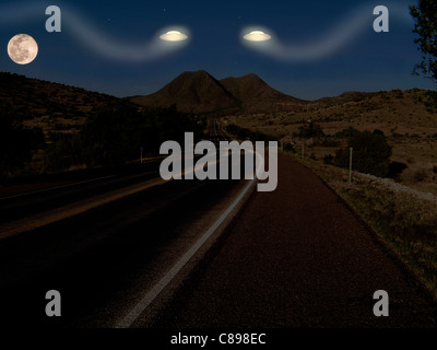 Due ufo scendere dal cielo sulla Highway 67 vicino Marfa, Texas di notte Foto Stock