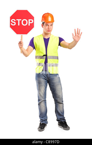 A piena lunghezza Ritratto di un lavoratore edile tenendo un cartello stradale stop Foto Stock