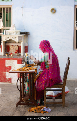 Donna indiana in sari di Rajasthani lavora a casa utilizzando la macchina da cucire in Nimaj village, Rajasthan, India Foto Stock