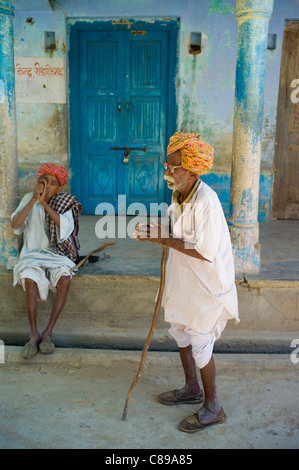 Uomini indiano, uno di tabacco da fumo da Chillam tubazione di argilla, in Rajasthani turbanti in Nimaj village, Rajasthan, India settentrionale Foto Stock