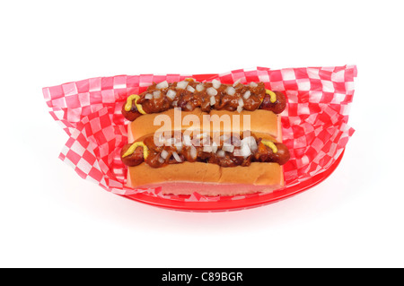 2 chili di cani con cipolle in rotoli di pane è servita nel retro rosso cesto in plastica sfondo bianco tagliato fuori Foto Stock