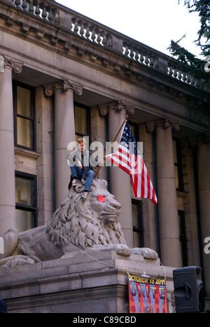 Protester tenendo una bandiera americana a occupare Vancouver rally di fronte alla galleria d'Arte di Vancouver, Vancouver, British Columbia, Canada. Foto Stock