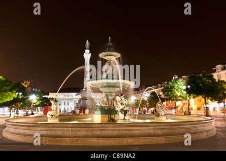 L'Europa, Portogallo, Lisbona, Baixa, vista della fontana di bronzo e la statua del re Pedro IV in Rossio di notte Foto Stock