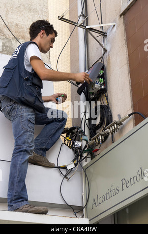 Tecnico che installa in fibra ottica internet a banda larga in un edificio residenziale Foto Stock