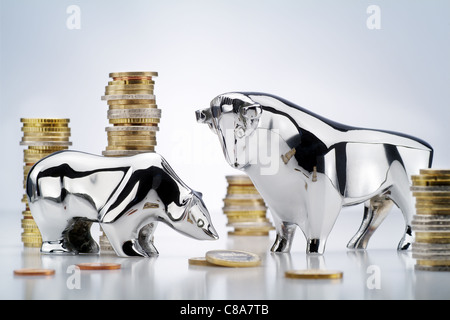 Toro e orso con monete metalliche in euro Foto Stock