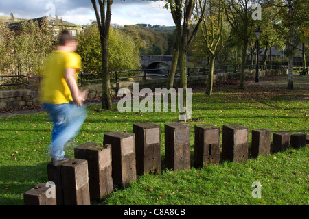 Giochi per bambini  bambini a giocare  sculture in legno sul Irwell Sentiero delle sculture Ramsbottom, East Lancashire, Regno Unito Foto Stock