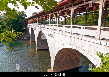 Arco cinese sposa di pietra su di un fiume in un parco della città Foto Stock