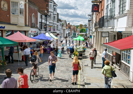 BANCARELLE DI CIBO ALL'APERTO GUILDFORD SURREY storico acciottolato High Street acquirenti in un giorno di mercato di prodotti locali occupato e soleggiato Guildford Surrey UK Foto Stock