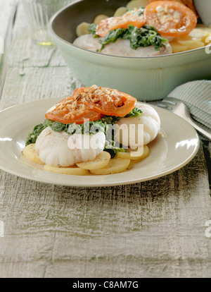 Fette di rana pescatrice con spinaci,i pomodori e patate Foto Stock