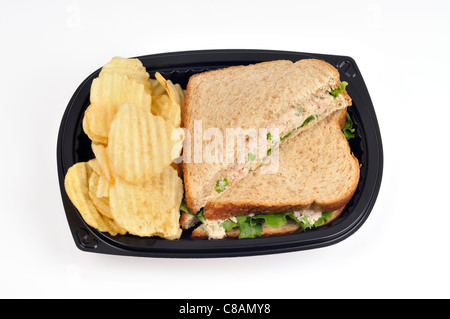 Tonno mayo panino con lattuga fatta con pane integrale tagliato a metà con rilievo potato chips in un takeaway contenitore in plastica su bianco, ritaglio. Foto Stock