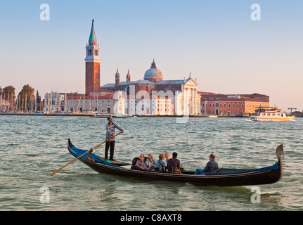 La chiesa di San Giorgio Maggiore, cercando di fronte a Piazza San Marco a Venezia con una gondola e turistico in primo piano. Foto Stock