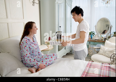 L'uomo portare mia moglie la colazione a letto Foto Stock
