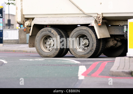 Un basso livello di vista delle ruote anteriori di un carrello che si muove lungo una strada Foto Stock