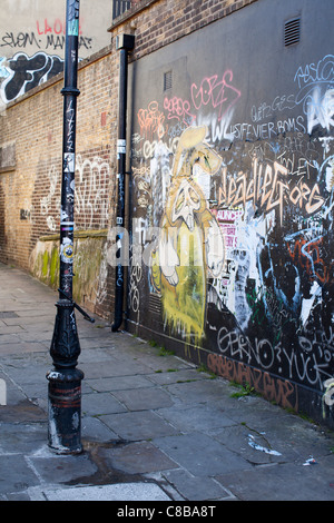 Un vicolo di modo in Shoreditch coperto di graffiti. Londra. Regno Unito. Foto Stock