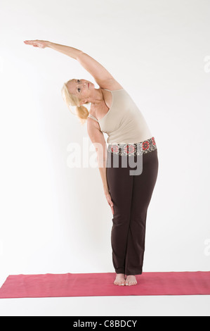 Donna matura facendo esercizio di stretching Foto Stock