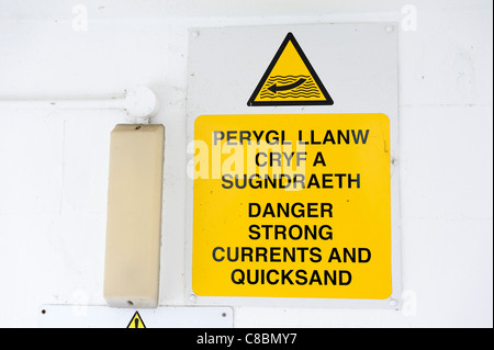 Pericolo forti correnti e QUICKSAND SIGN in inglese e gallese Foto Stock