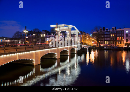 Il Magere Brug di notte, sul fiume Amstel di Amsterdam, Paesi Bassi Foto Stock