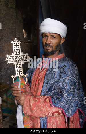 Elk200-3206v Etiopia Lalibela, rock cut chiesa, XII-XIII c, Bet Meskel-Danaghel, sacerdote holding cross Foto Stock