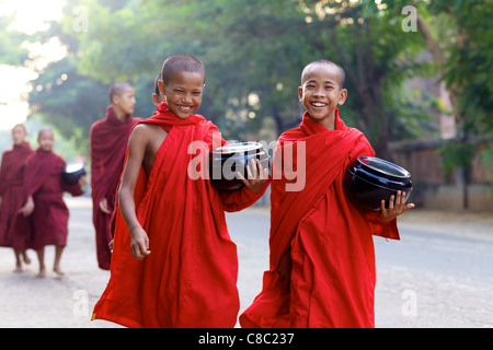 Unidentified giovane debuttante monaci portando bocce sulla mattina alms a piedi Foto Stock