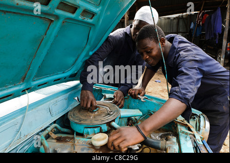 Partecipante meccanica lavorando su una vettura a motore, Thika, Kenya. Foto Stock