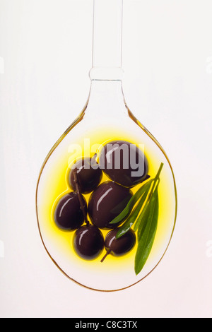 Olive nere in cucchiaio di olio Foto Stock