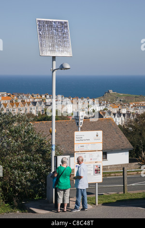 Persone che acquistano i biglietti per il parcheggio da un solare macchina motorizzata in costosi Trenwith parcheggio auto. St Ives Cornwall Inghilterra UK Gran Bretagna Foto Stock