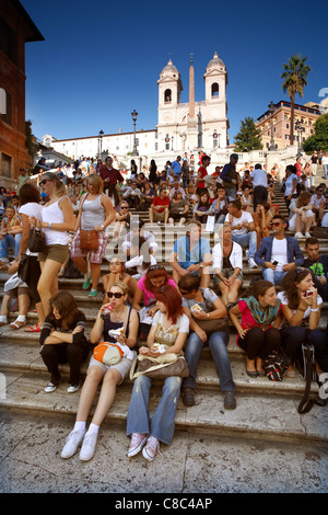 I turisti seduti sulla scalinata di Piazza di Spagna al di sopra della Piazza di Spagna a Roma, Italia. Foto Stock