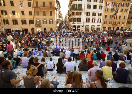 I turisti seduti sulla scalinata di Piazza di Spagna al di sopra della Piazza di Spagna a Roma, Italia. Foto Stock