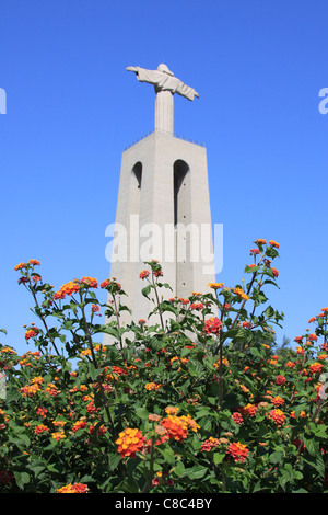 I fiori e la statua del Cristo Rei di Lisbona, Portogallo Foto Stock