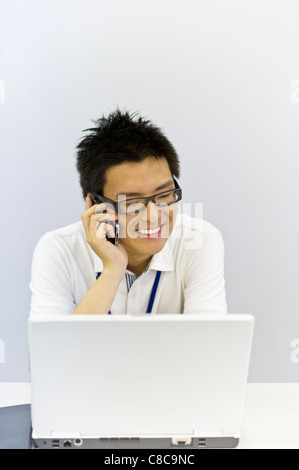 Giovane uomo in business casual parlando sullo smartphone Foto Stock