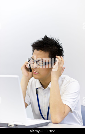 Giovane uomo in business casual parlando sullo smartphone Foto Stock