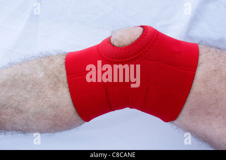 Il neoprene supporto ginocchio su una gamba ferita Foto Stock