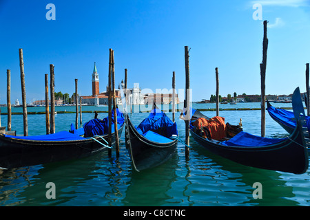 Gondole attraccate al poli di ormeggio Piazza San Marco Venezia Italia Foto Stock