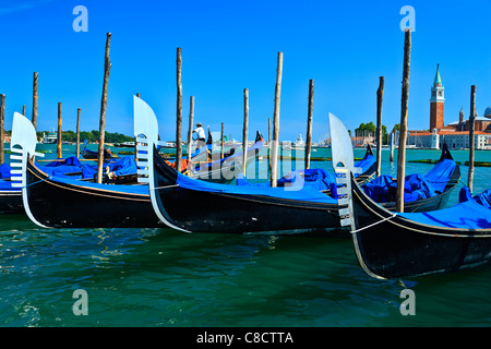 Gondole attraccate al poli di ormeggio Piazza San Marco Venezia Italia Foto Stock