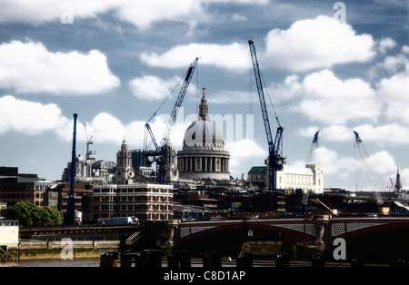 St Pauls Cathedral dome incorniciato dalle moderne gru, Londra in alto contrasto Foto Stock