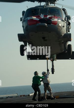 Il fissaggio di un gancio per un MH-60S Sea Hawk elicottero assegnato all'Eightballers di elicottero di mare squadrone di combattimento (HSC) 8 Foto Stock