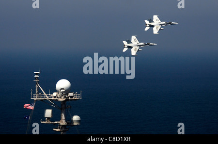 F/A-18C calabroni assegnato al dragoni dorati di Strike Fighter Squadron (VFA) 192 volare oltre la portaerei Stennis Foto Stock