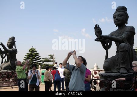 I TURISTI CINESI IN VISITA & fotografare santuario buddista Po Lin tempio, l'Isola di Lantau, Hong Kong, Cina Foto Stock