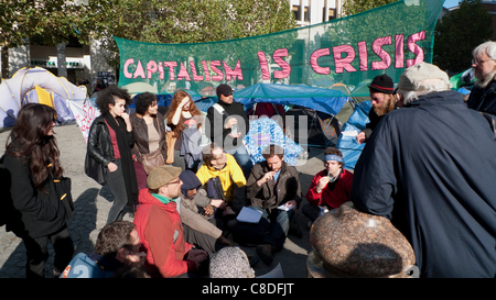 Un gruppo di manifestanti a occupare il movimento dimostrazione 19/10/2011 si riuniranno per discutere la futura strategia per la protesta di fronte Cattedrale di San Paolo a Londra Inghilterra. Il capitalismo è la crisi Banner. KATHY DEWITT Foto Stock