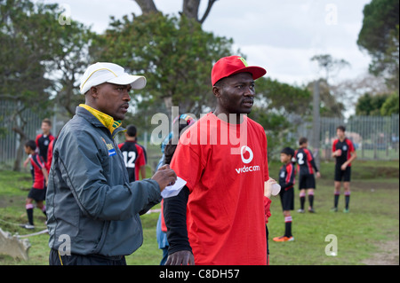 Gli allenatori di calcio a guardare una partita di una squadra giovanile a Città del Capo in Sud Africa Foto Stock