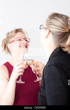 Due giovani donne godendo di partito di business. Foto Stock